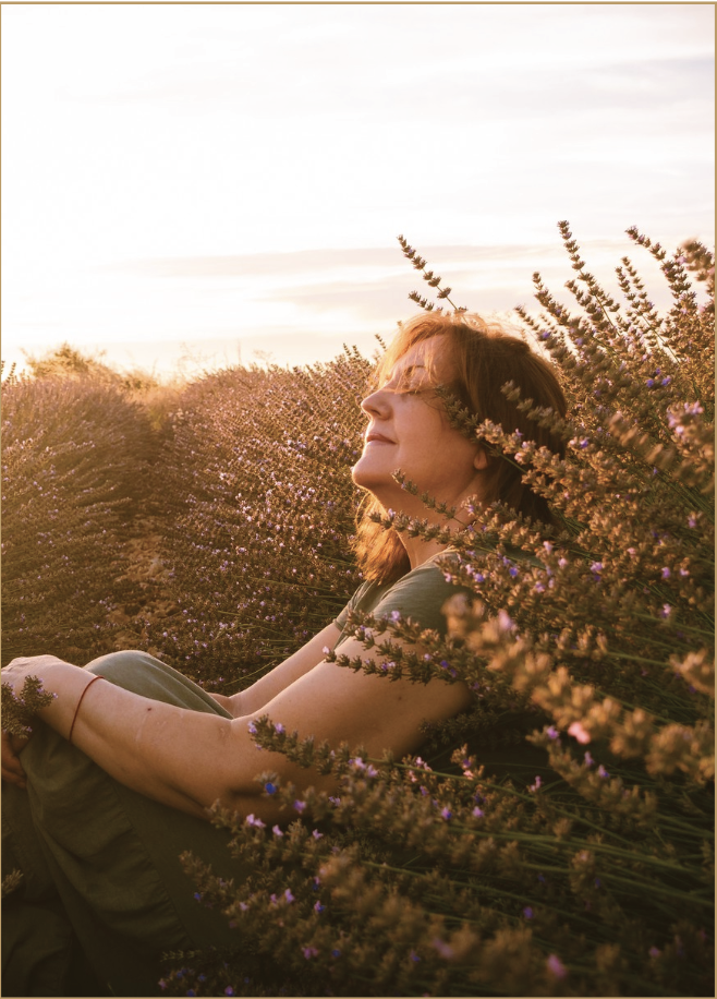Woman relaxing in lavender field at sunset